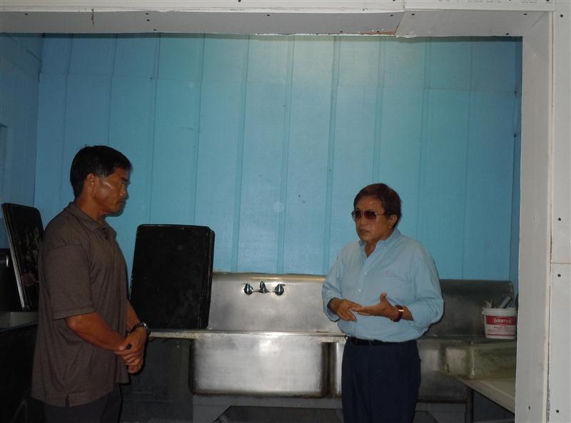 Bakery owner George Kanemitsu, right, speaks with DOH inspector Dean Kagawa at the bakery's washing station. Photo by Catherine Cluett