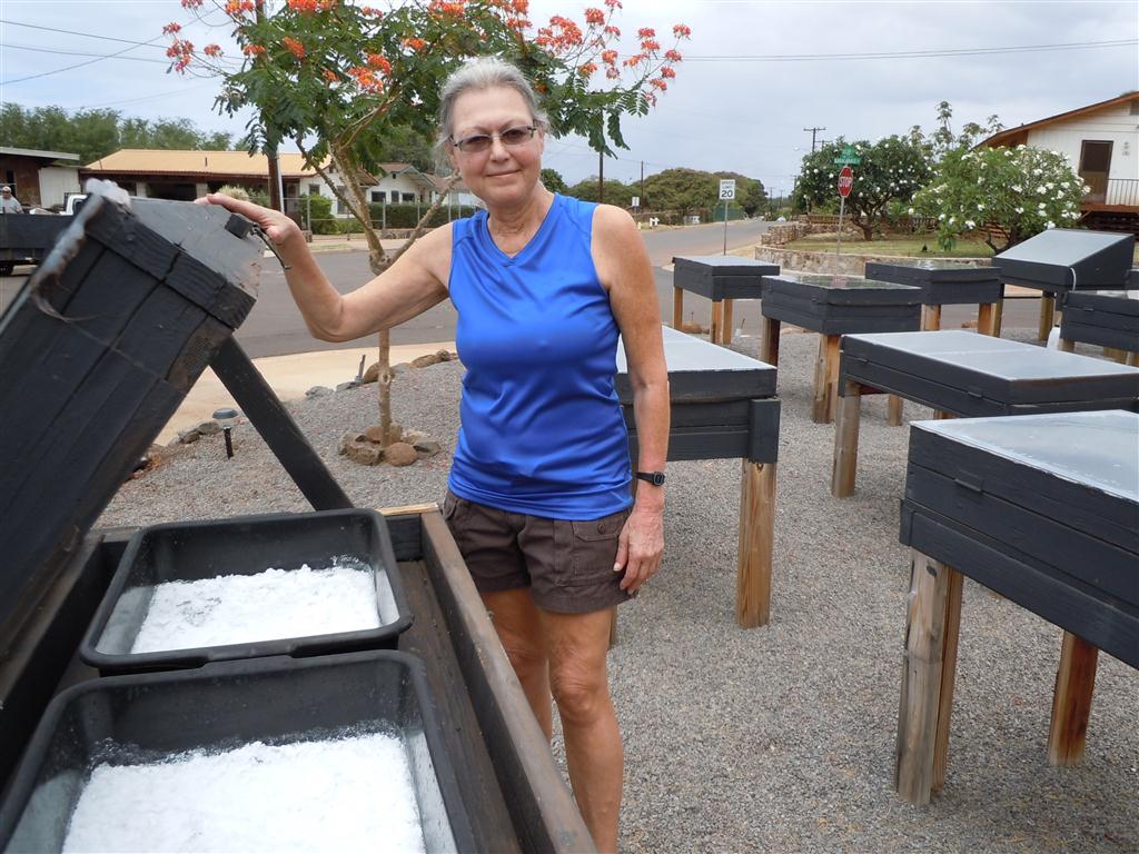 Salt master Nancy Gove turns sea water to salt in her Kaunakakai yard. Photo by Catherine Cluett