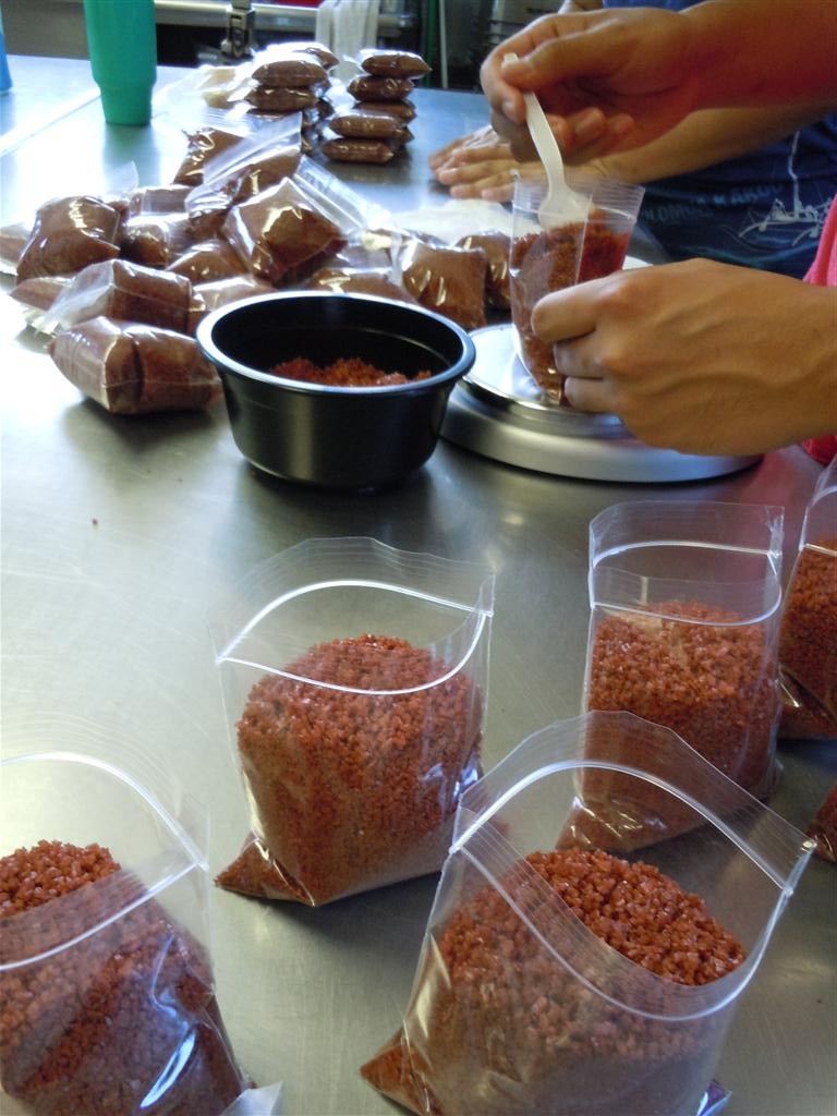 Molokai gourmet sea salt company Pacifica Hawaii packages Red Alaea salt for shipment. Photo by Catherine Cluett