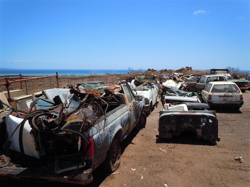 Junk cars wait to be crushed before being transported to Oahu for recycling. Photo by Catherine Cluett